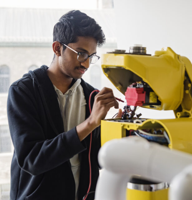 Een Indiase ingenieur werkt aan een robot in de Indiase technologiesector